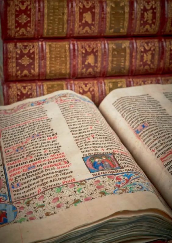 Opengeslagen middeleeuws breviarium met miniaturen en leren banden