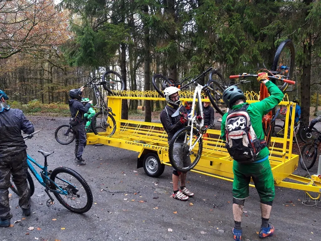 Group of mountain bikers loading bikes onto Cap Semois' yellow bike trailer