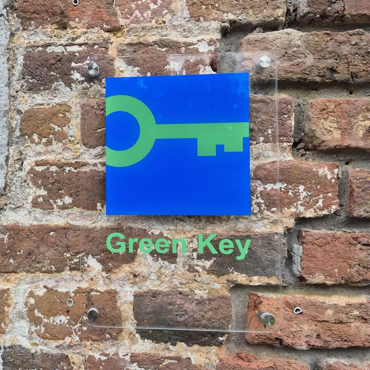 Green Key-plaquette op de bakstenen gevel van ArdenNest