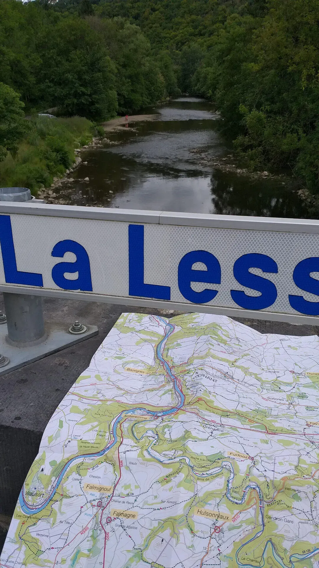 Wandelkaart op brugrand met bord La Lesse en uitzicht op de rivier