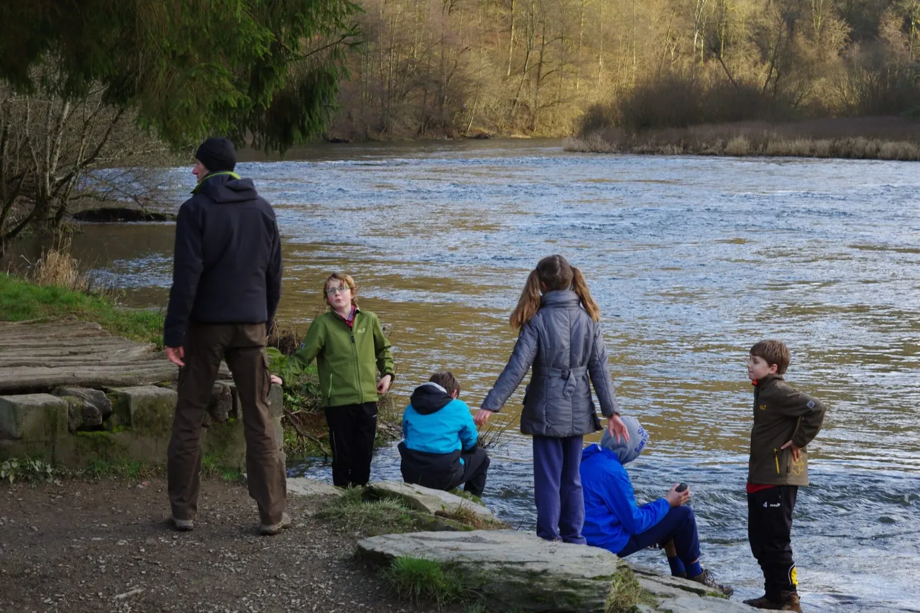 Gezin met kinderen speelt aan de oever van de Semois