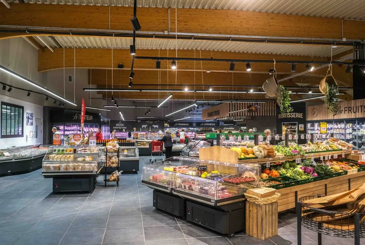 Ruim interieur van Intermarché met verse groente- en fruitafdeling