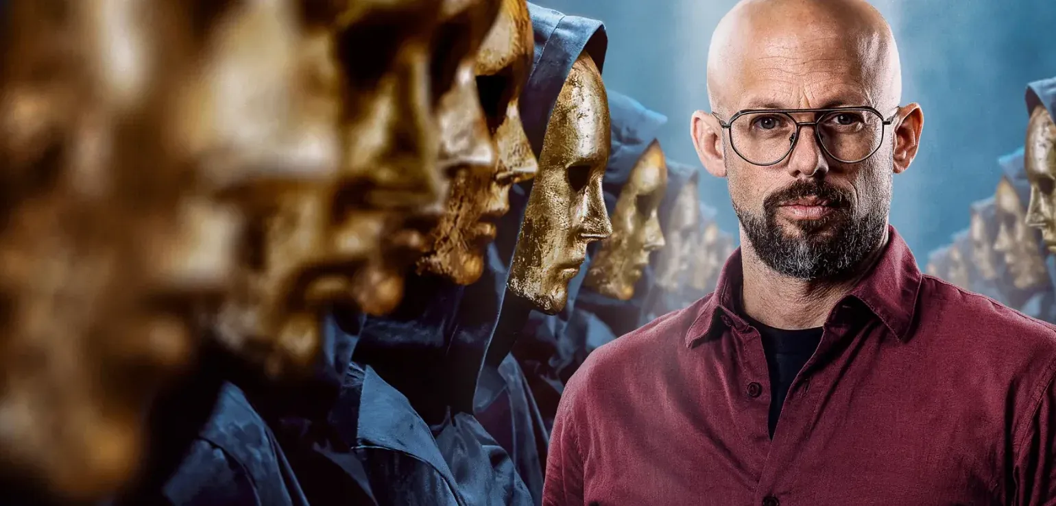 Het VTM-beeld van De Verraders 2026: presentator Staf Coppens tussen de gouden maskers (© VTM)