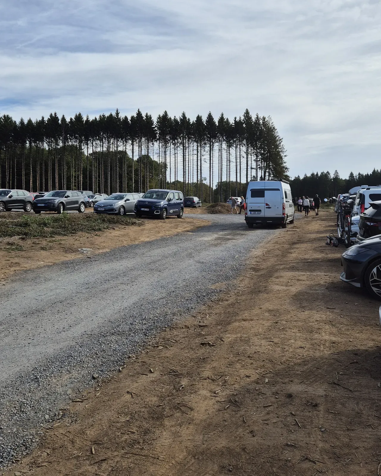The free car park on Rue d'Herbeumont in Sainte-Cécile, full of cars on a sunny Sunday