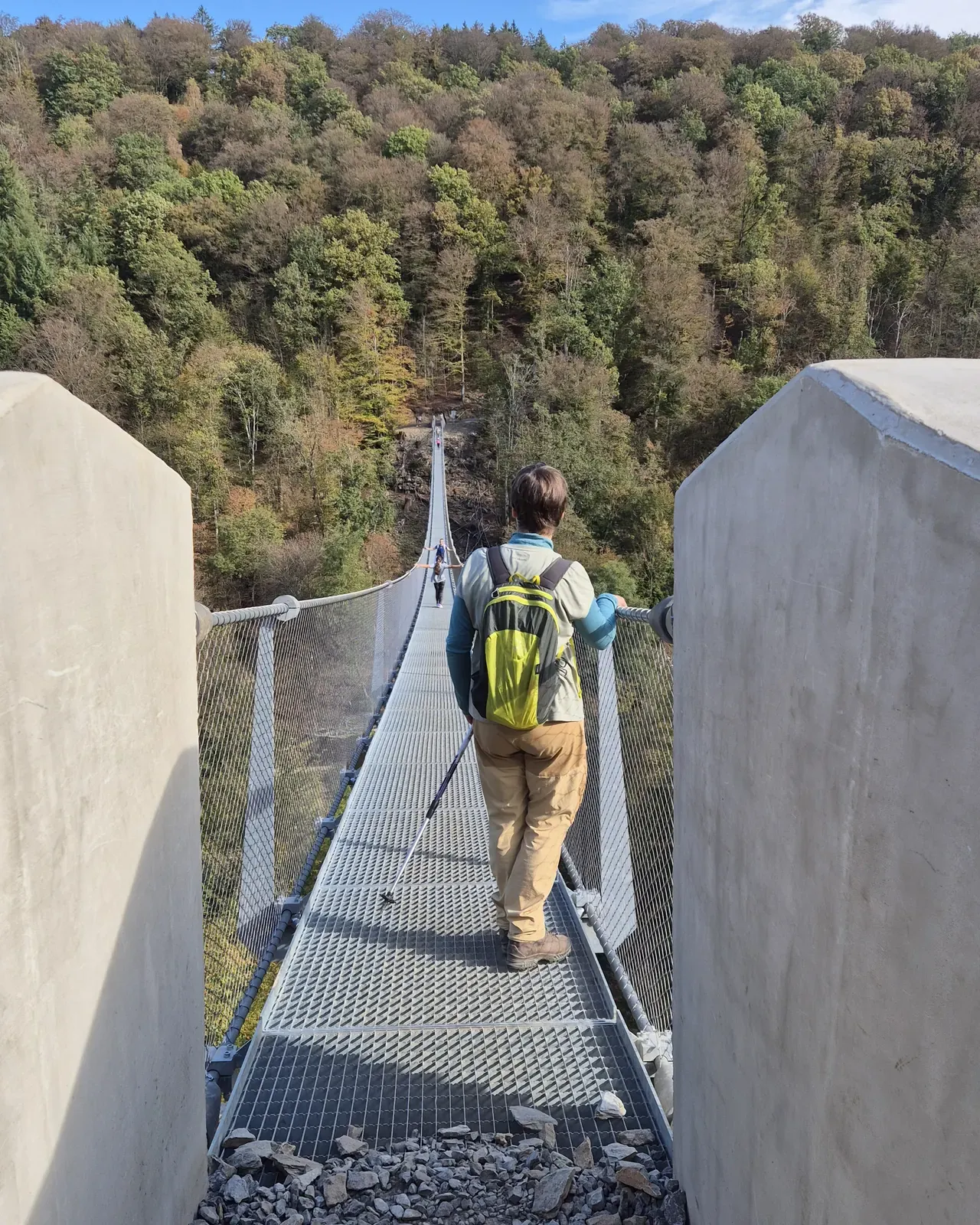 Randonneuse entre les piliers de béton à l'entrée de la passerelle